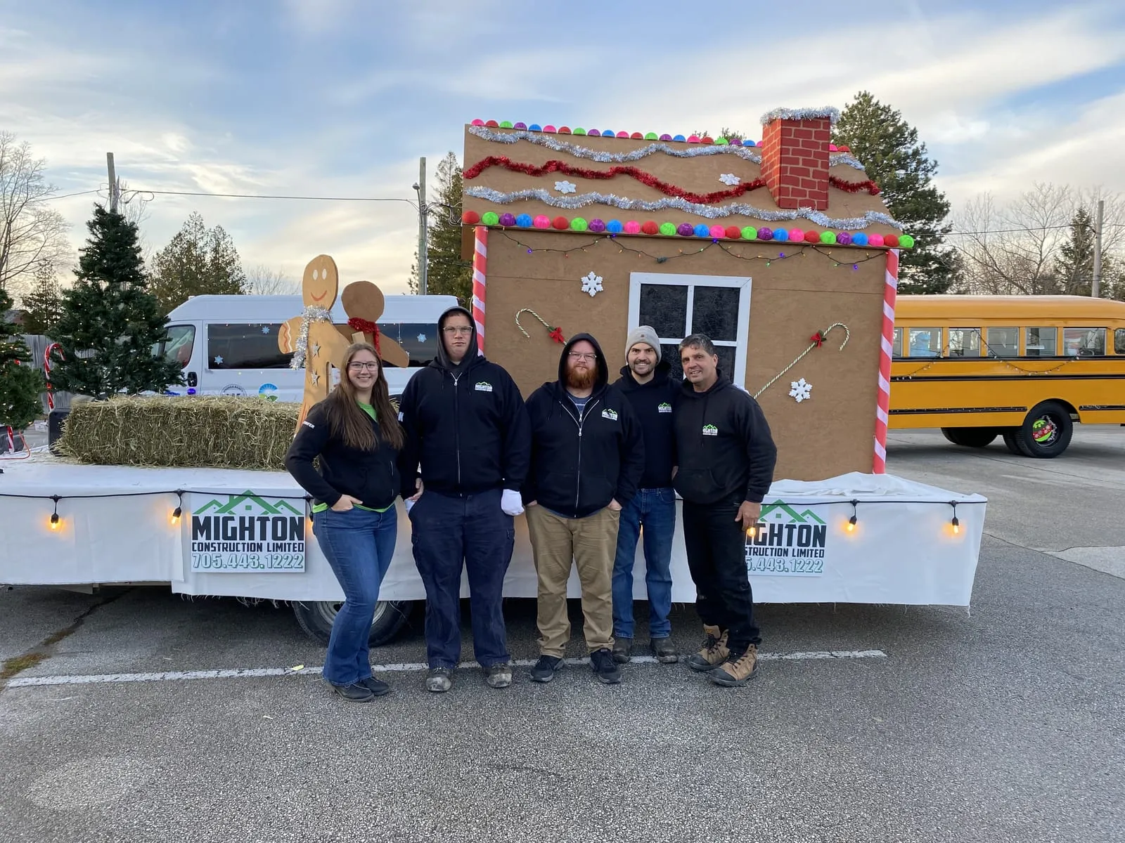 The Mighton Construction team stands in front of the company's gingerbread-house float before the 2023 Wasaga Beach Santa Claus Parade